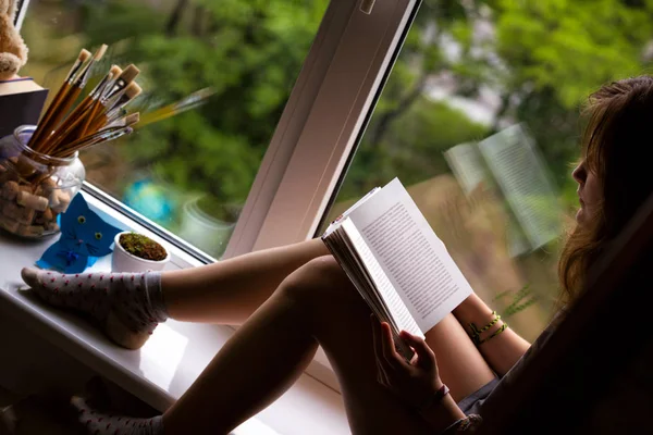 Teenager Mädchen sitzt auf einer Fensterbank — Stockfoto