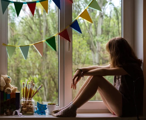 Tonåring flicka sitter på fönsterblecket — Stockfoto