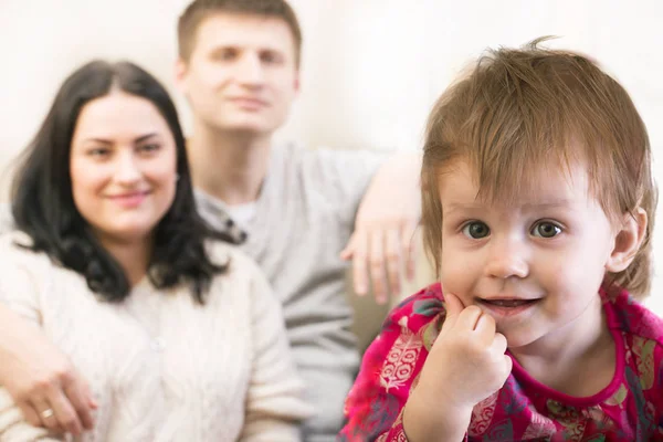 Little smiling child girl with the parents at the distance — Stock Photo, Image