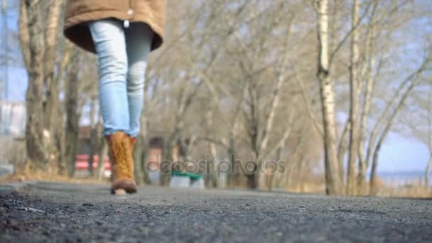 Молодая девушка гуляет на улице в солнечный весенний день — стоковое видео