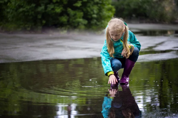 Girl playing in a puddle — Stock Photo, Image
