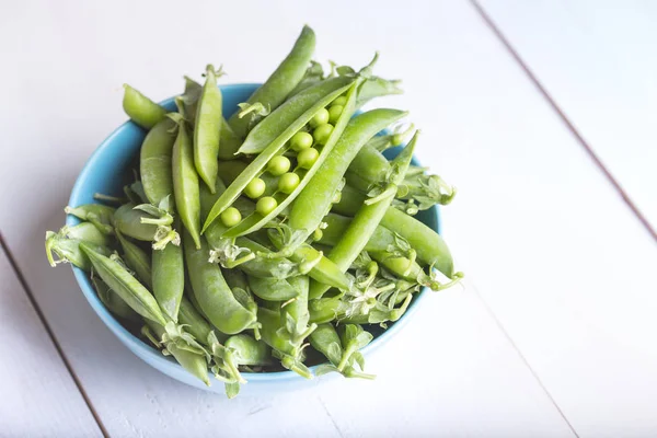 Guisantes verdes sobre un fondo blanco — Foto de Stock