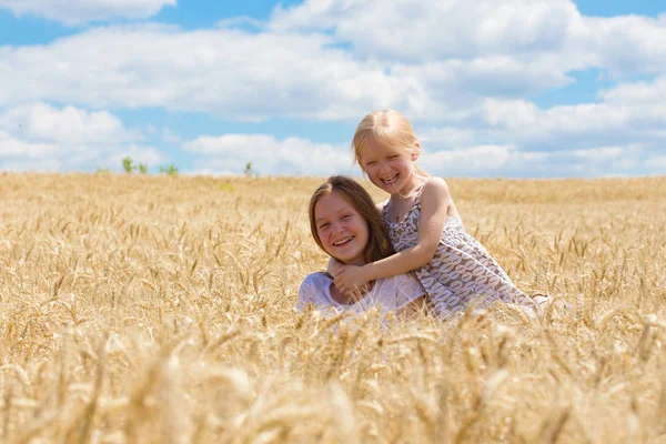Smiling sisters at the field — Stock Photo, Image