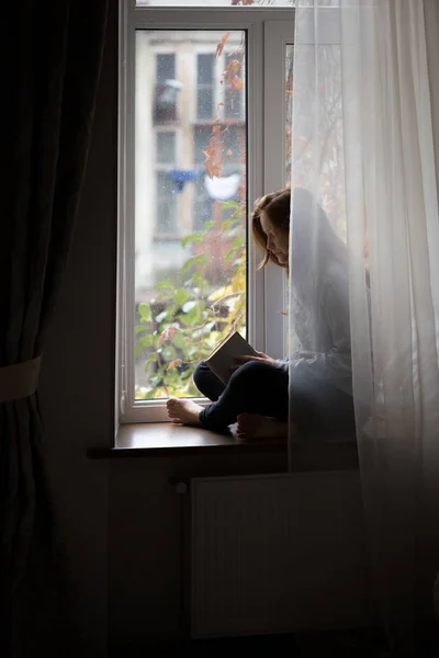 Tiener meisje zit op een vensterbank — Stockfoto