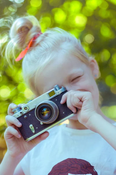 Lilla vackra flicka med retro kamera — Stockfoto