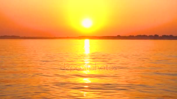 Κόκκινο ήλιο που δύει πάνω από το ήσυχο νερό — Αρχείο Βίντεο