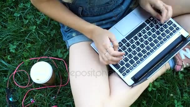 Ragazza con computer portatile seduto su un'erba — Video Stock