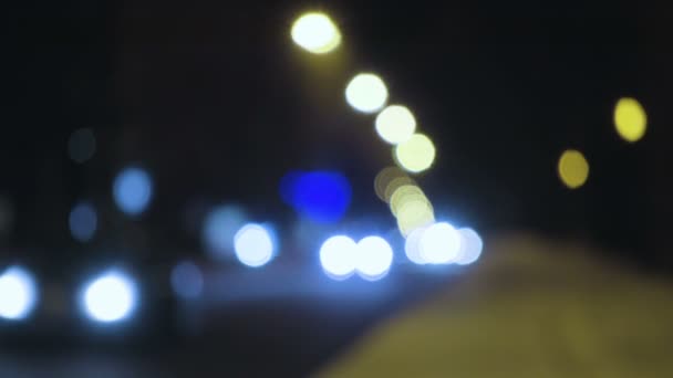 Luces borrosas de coches en una calle nevada de invierno — Vídeos de Stock