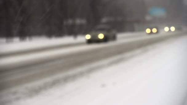 Rozmazané auta světla na zimní zasněžené ulici — Stock video