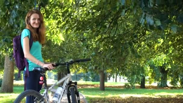 Mädchen fährt mit dem Fahrrad durch die Straßen und durch den Stadtpark — Stockvideo
