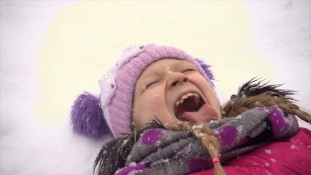 Παιδί κορίτσι που πιάνει νιφάδες χιονιού ένας με τη γλώσσα της κλείσιμο βίντεο — Αρχείο Βίντεο