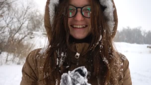 Lächelndes Mädchen, das Spaß am verschneiten Wintertag hat — Stockvideo