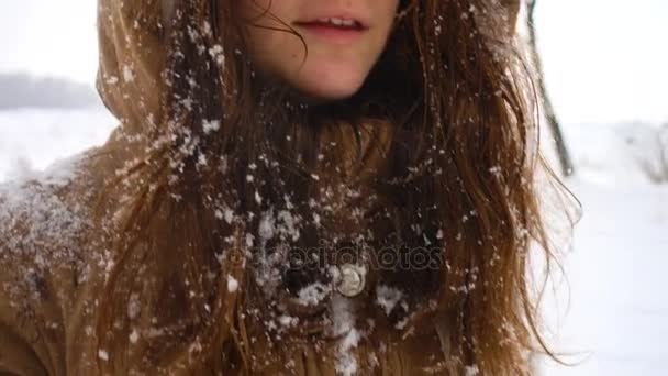 Улыбающаяся девушка веселится в снежный зимний день — стоковое видео