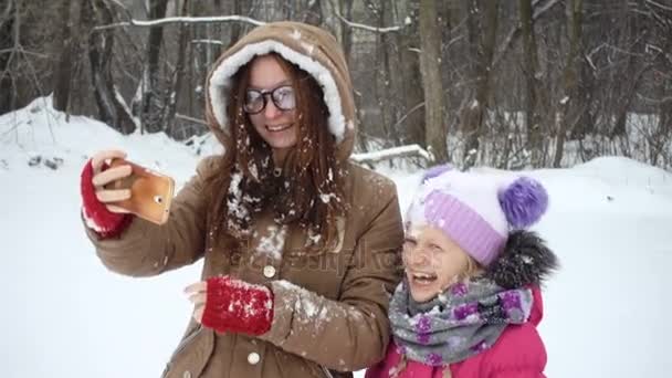 Gülen kız bir selfie karlı kış gününde yapma — Stok video