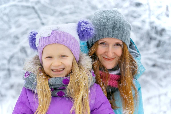 Mère avec fille souriante lors d'une promenade hivernale — Photo
