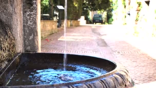 Вода течет у уличного фонтана в маленьком итальянском городке — стоковое видео