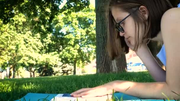 Девочка читает на траве — стоковое видео
