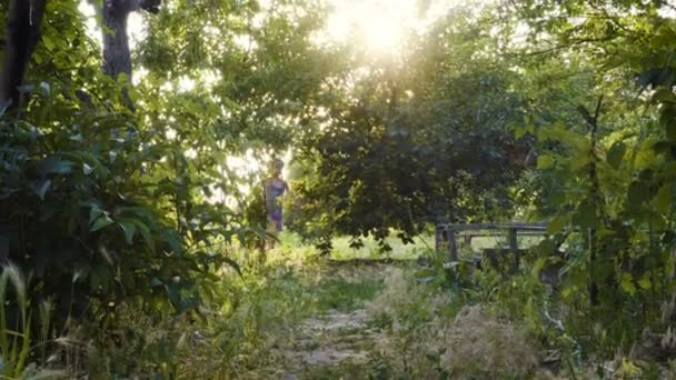 Barn flicka kör på marken med nakna fötter på solnedgången tid — Stockvideo