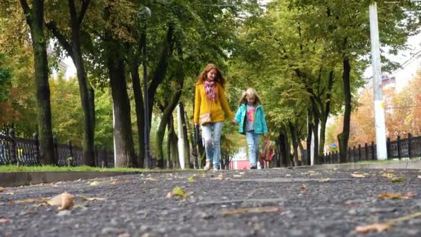 Anne ve kızı boş bir sonbahar sokak üzerinde — Stok video