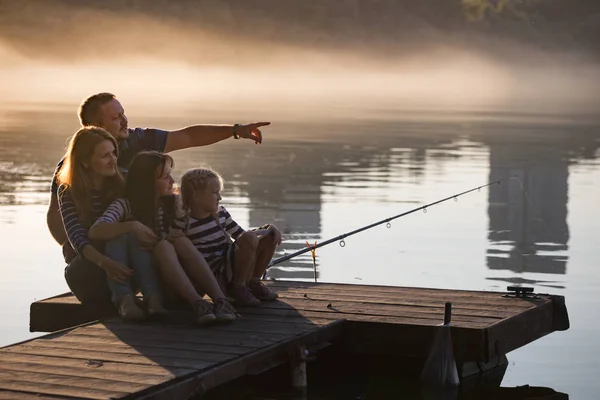 Lycklig familj sitter på piren — Stockfoto