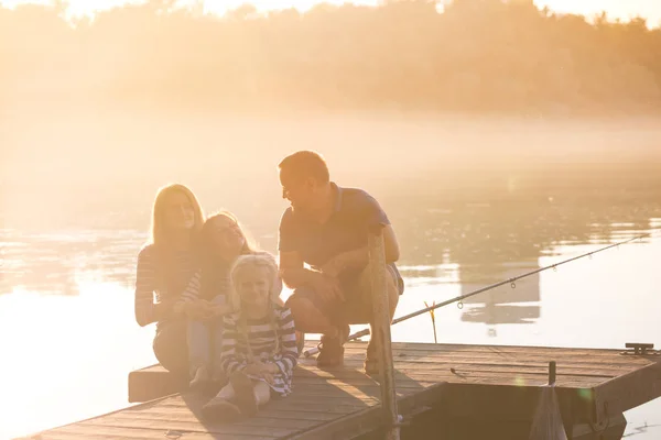 Glückliche Familie sitzt auf der Seebrücke — Stockfoto