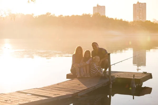 Glückliche Familie sitzt auf der Seebrücke — Stockfoto