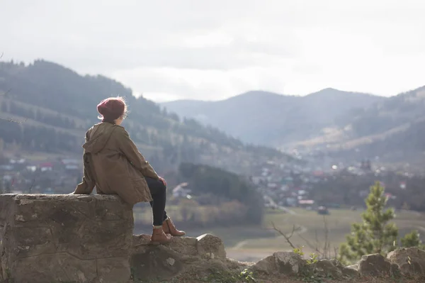 Дівчина хіпстер сидить на фоні гір — стокове фото