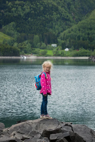 Little blonde girl at the shore of norwegian lake — Stock Photo, Image