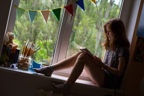 窓辺に座っている十代の女の子 — ストック写真