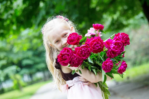 Ragazza con un mazzo di peonie — Foto Stock