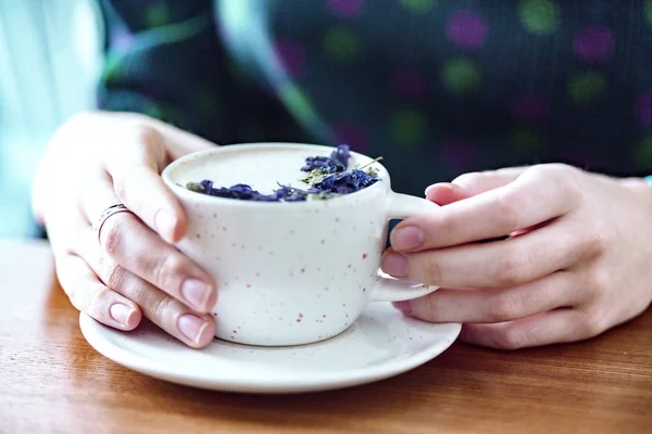 Dziewczyna ręce trzymając filiżankę cappuccino — Zdjęcie stockowe