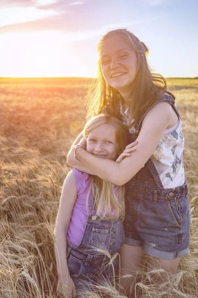 Hermosa chica hermanas en el campo de trigo — Foto de Stock