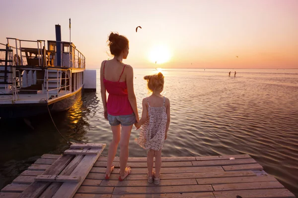 日没の光の桟橋に家族 母と娘の立っています — ストック写真