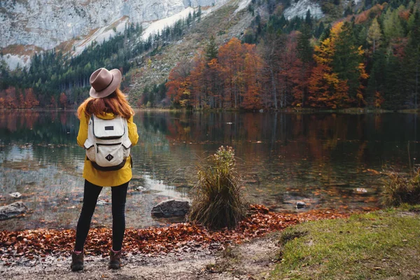 Girl stands on the shore of a mountain lake — Stock Photo, Image