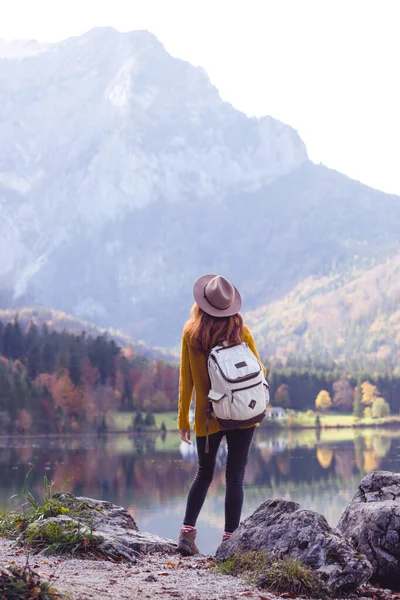 Girl stands on the shore of a mountain lake — Stock Photo, Image