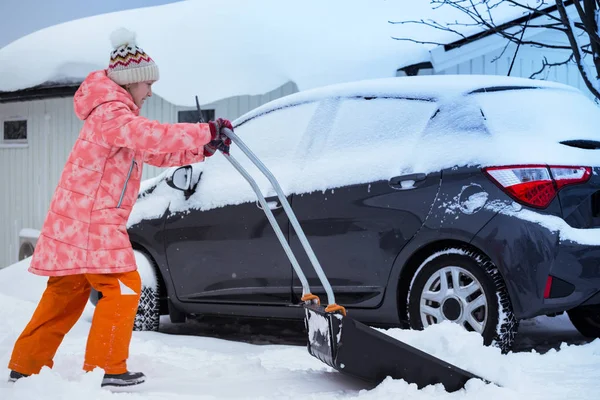 Child girl cleans snow with a shovel — Stock Photo, Image