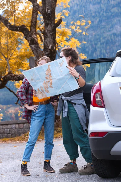 Mädchen mit Karte steht neben dem Auto — Stockfoto