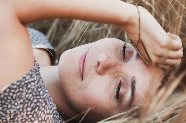 Girl lies in dry grass — Stock Photo, Image