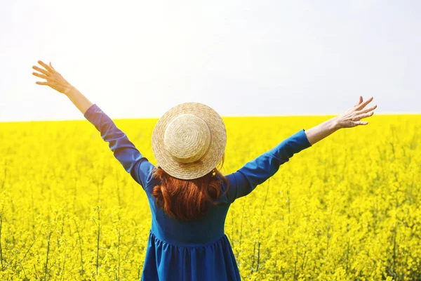 Ragazza che cammina in un campo di colza gialla — Foto Stock