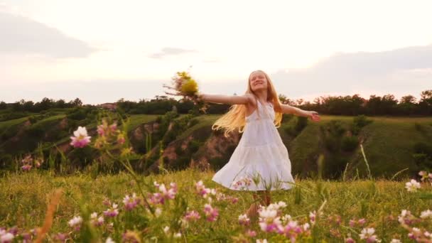 楽しいダンスと夜のフィールドで回転する花束を持つ子供の女の子 — ストック動画