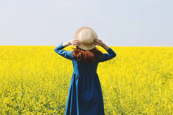 Menina andando em um campo de colza amarela — Fotografia de Stock