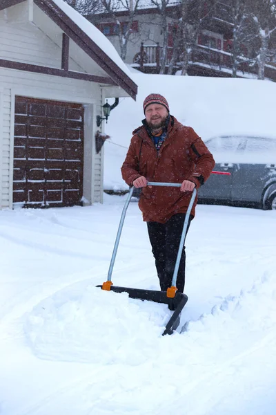 Homem limpa neve com uma pá — Fotografia de Stock