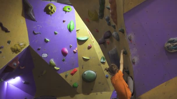 活跃的小女孩爬上体育馆的室内卵石墙 — 图库视频影像