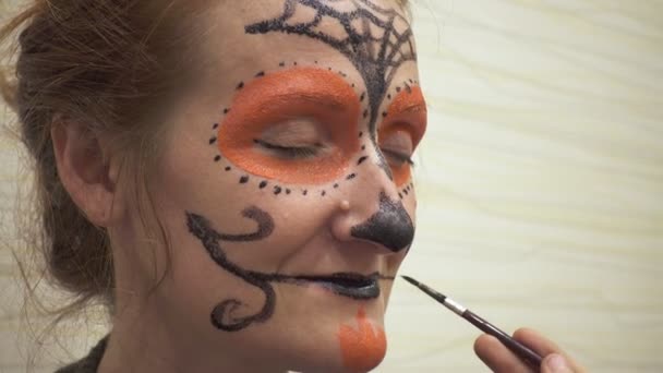 母と娘がハロウィンのお祝いの準備をし 絵を描く怖い顔を作る — ストック動画
