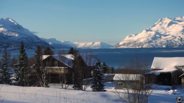 冬季挪威全景 房子坐落在海岸上 远处是美丽的雪山 — 图库视频影像