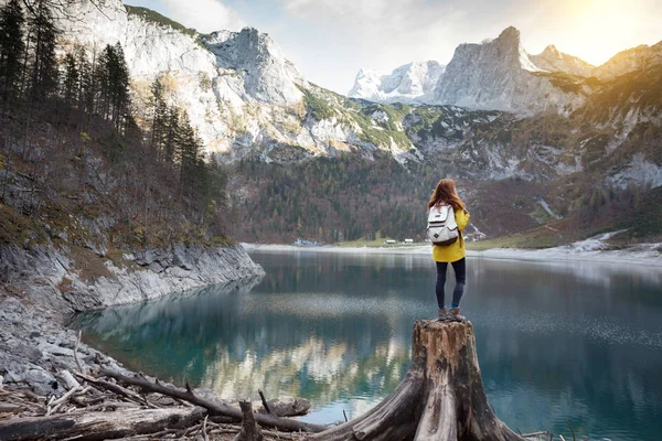 Menina fica na margem de um lago de montanha — Fotografia de Stock