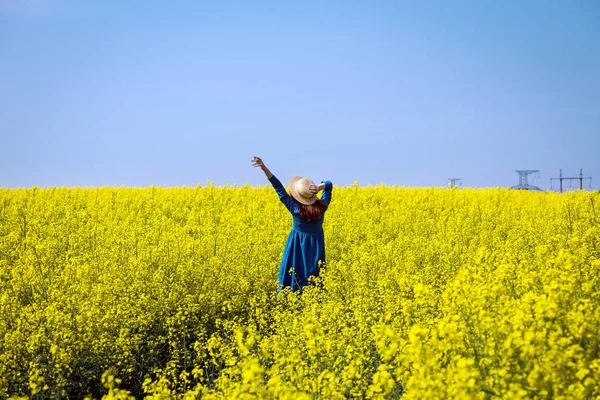 Menina andando em um campo de colza amarela — Fotografia de Stock