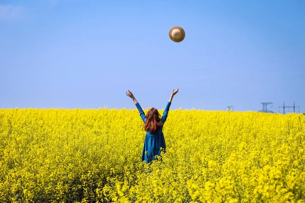 Menina andando em um campo de colza amarela — Fotografia de Stock
