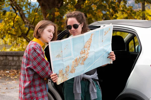 Mädchen mit Karte steht neben dem Auto — Stockfoto