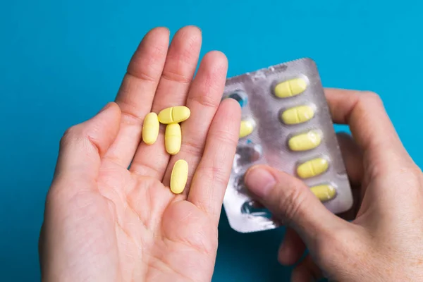 Frau Gießt Tabletten Von Einer Hand Zur Anderen — Stockfoto